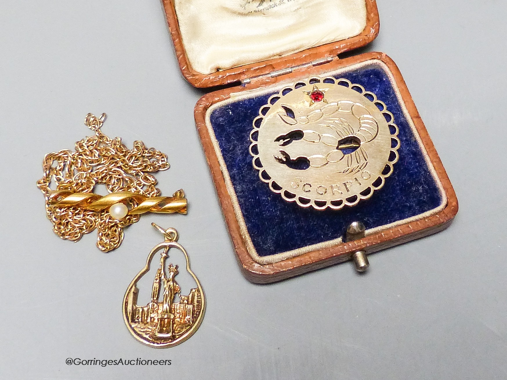 A modern 9ct gold Scorpio pendant, a 9ct chain, a yellow metal bar brooch(a.f.) and gilt sterling pendant, (9ct and yellow metal gross 22.8 grams.